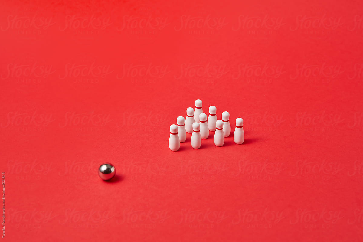Bowling ball and pins on red background