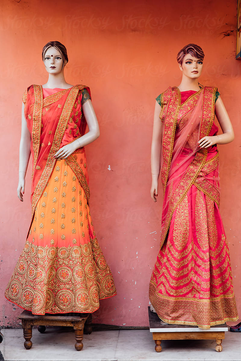 Plastic models wearing red and orange saris outside