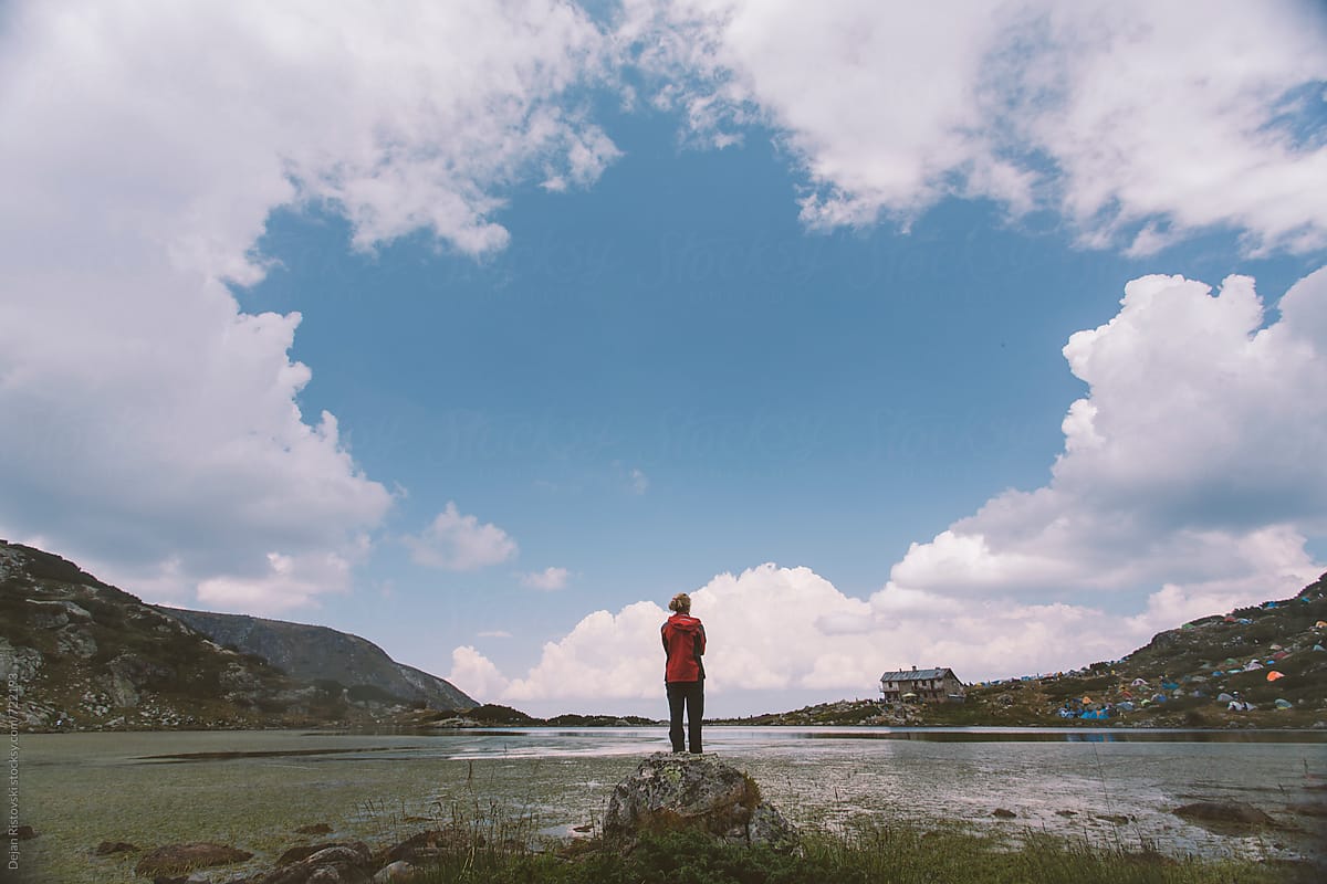 A woman standing on a mountain lake