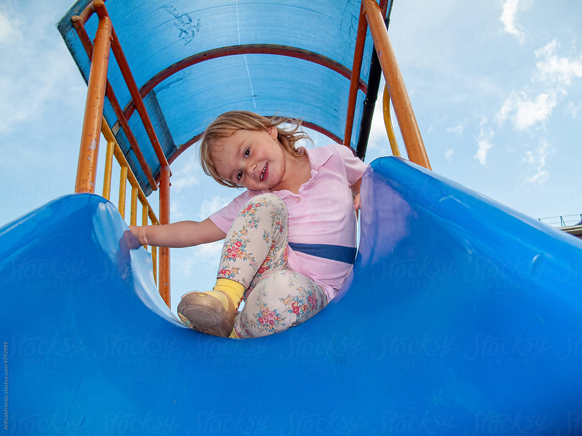 cute girl on playground slide