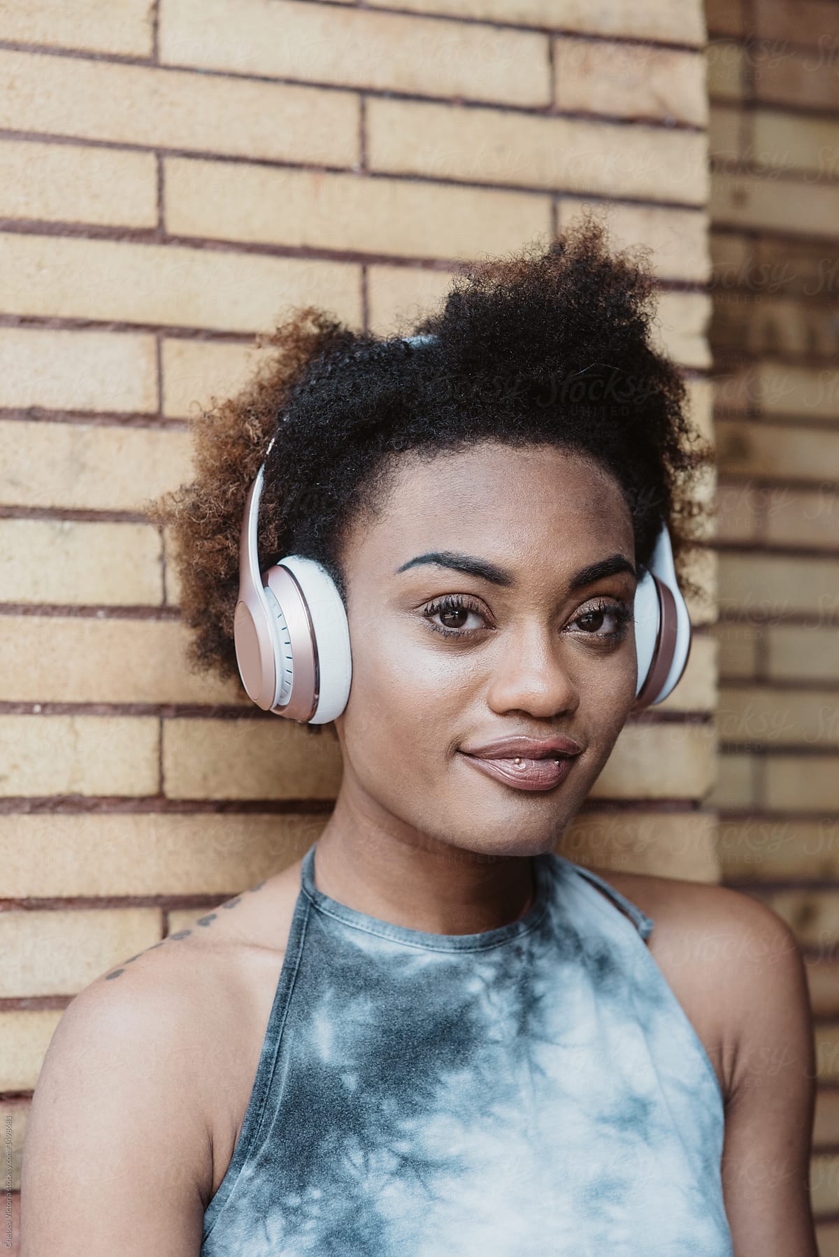 An African American Woman Listening To Music In The City By Stocksy