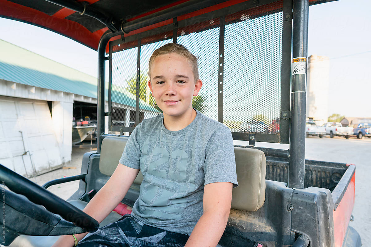 Young boy driving farm vehicle
