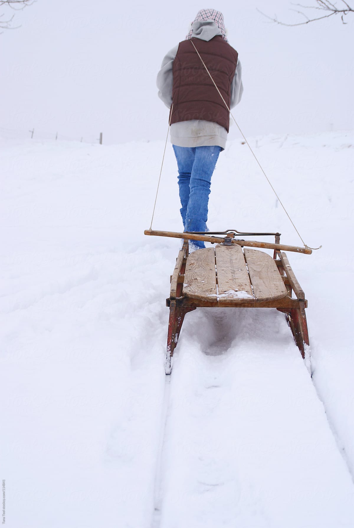 young girl pulling sled in snow