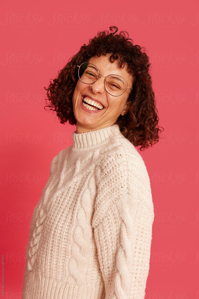 Joyful woman laughing and looking at camera in studio
