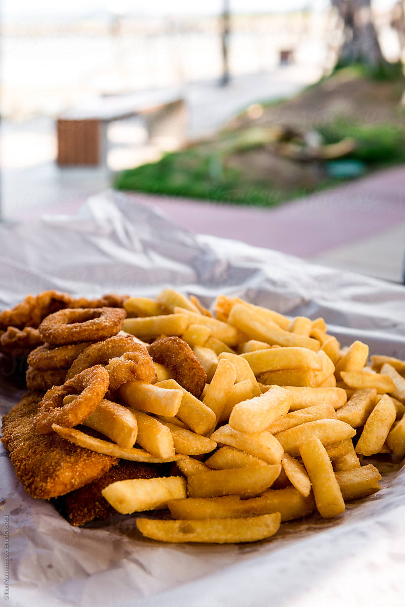 takeaway fish and chips on a picnic table by the sea
