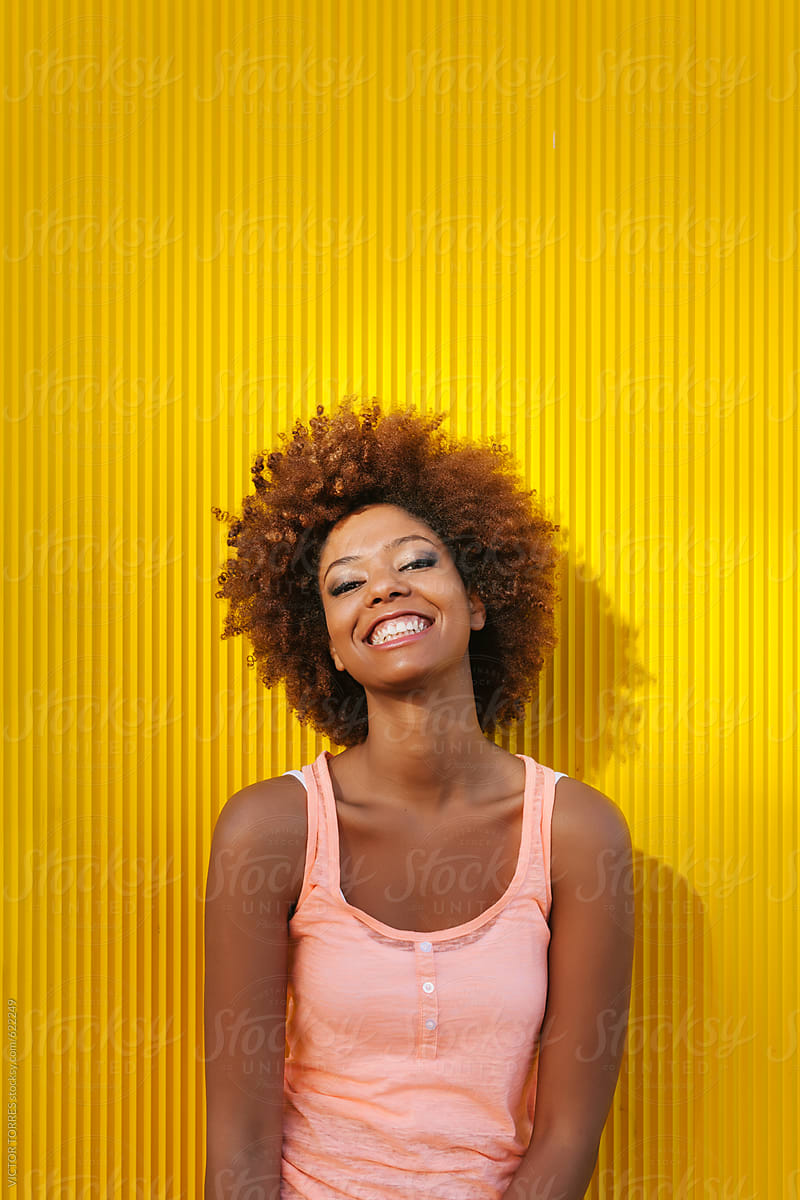 Latin American Afro Woman Against a Yellow Background in a Summer Day