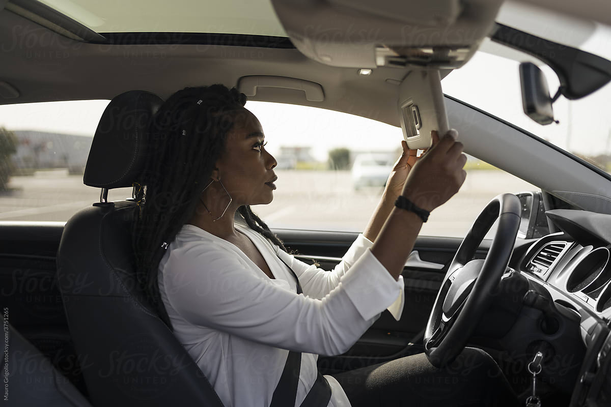 Woman looking in the mirror in the car
