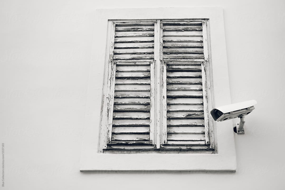 White vintage window with a surveillance camera