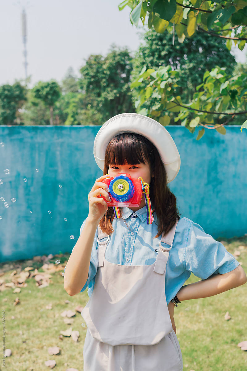 Young Asian women playing with camera bubble machine