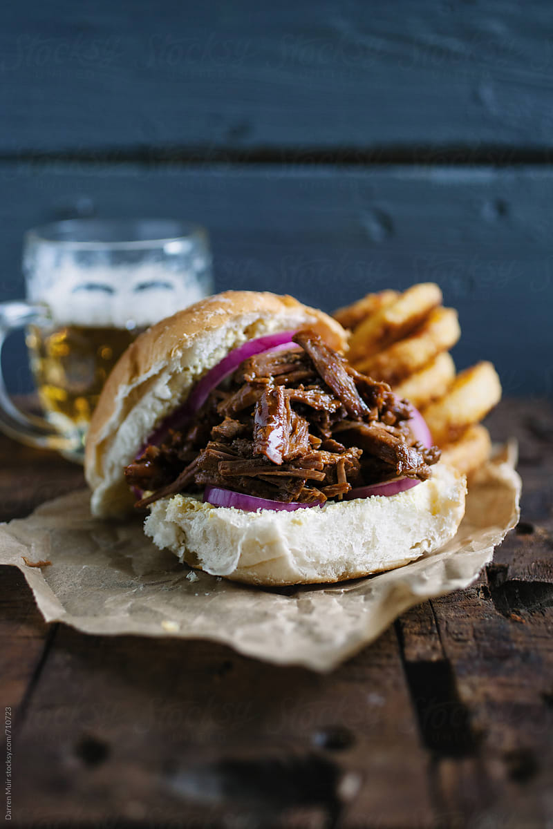 Barbecue pulled beef brisket burger with beer and onion rings.