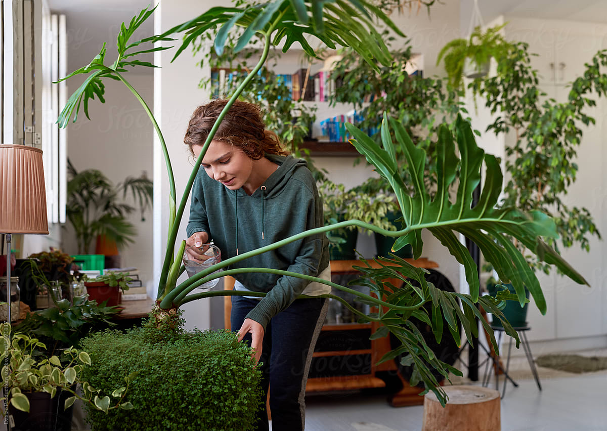 Happy free spirited woman in her plant filled apartment