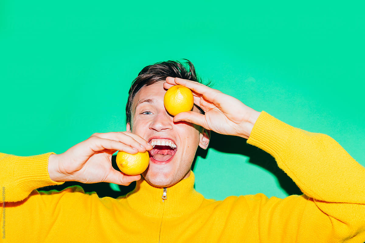 Man in Yellow Holding Lemons