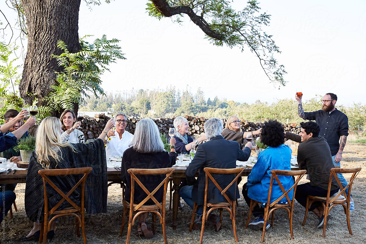 Group Of Friends Doing A Toast At Outdoor Dinner Party By Stocksy Contributor Trinette Reed