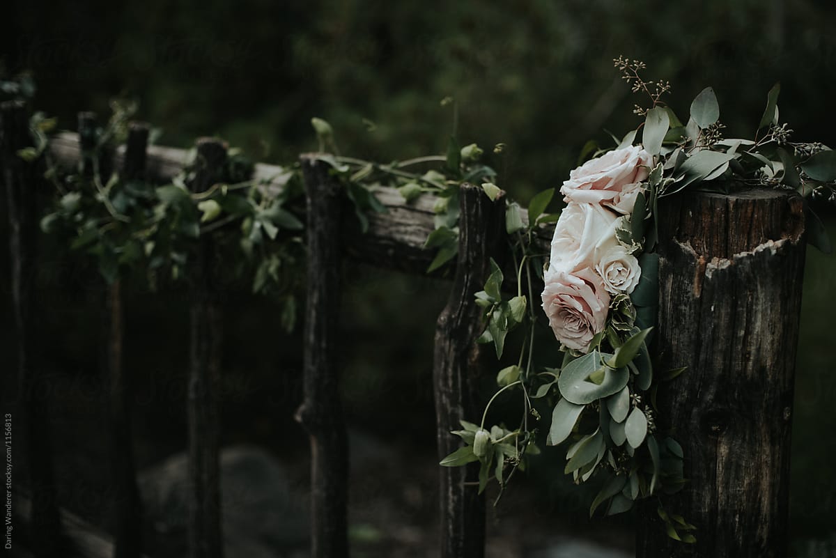 Romantic garden rose and eucalytpus flower garland on fence for outdoor wedding