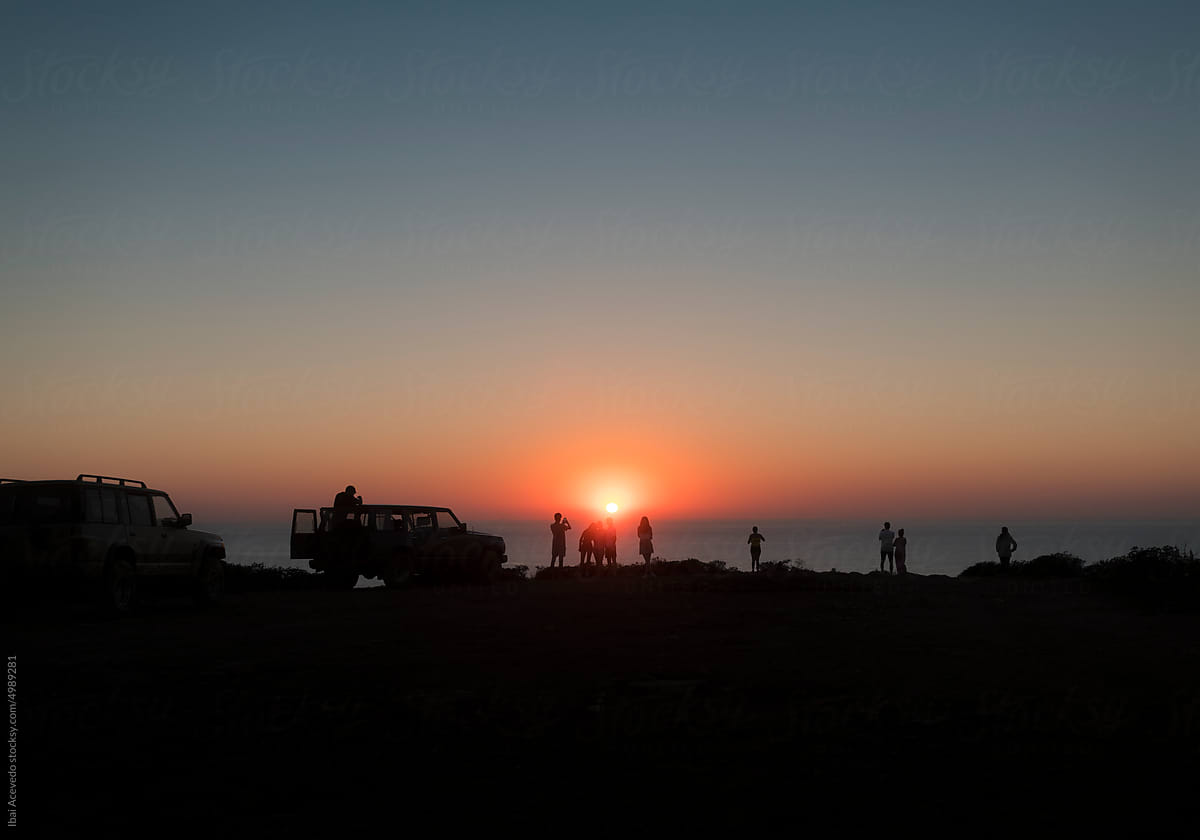 Family silhouettes enjoying sunset view after 4x4 tour