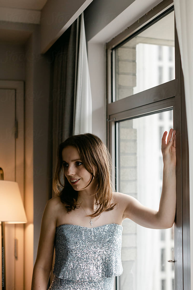 Bride Standing in Window at Hotel
