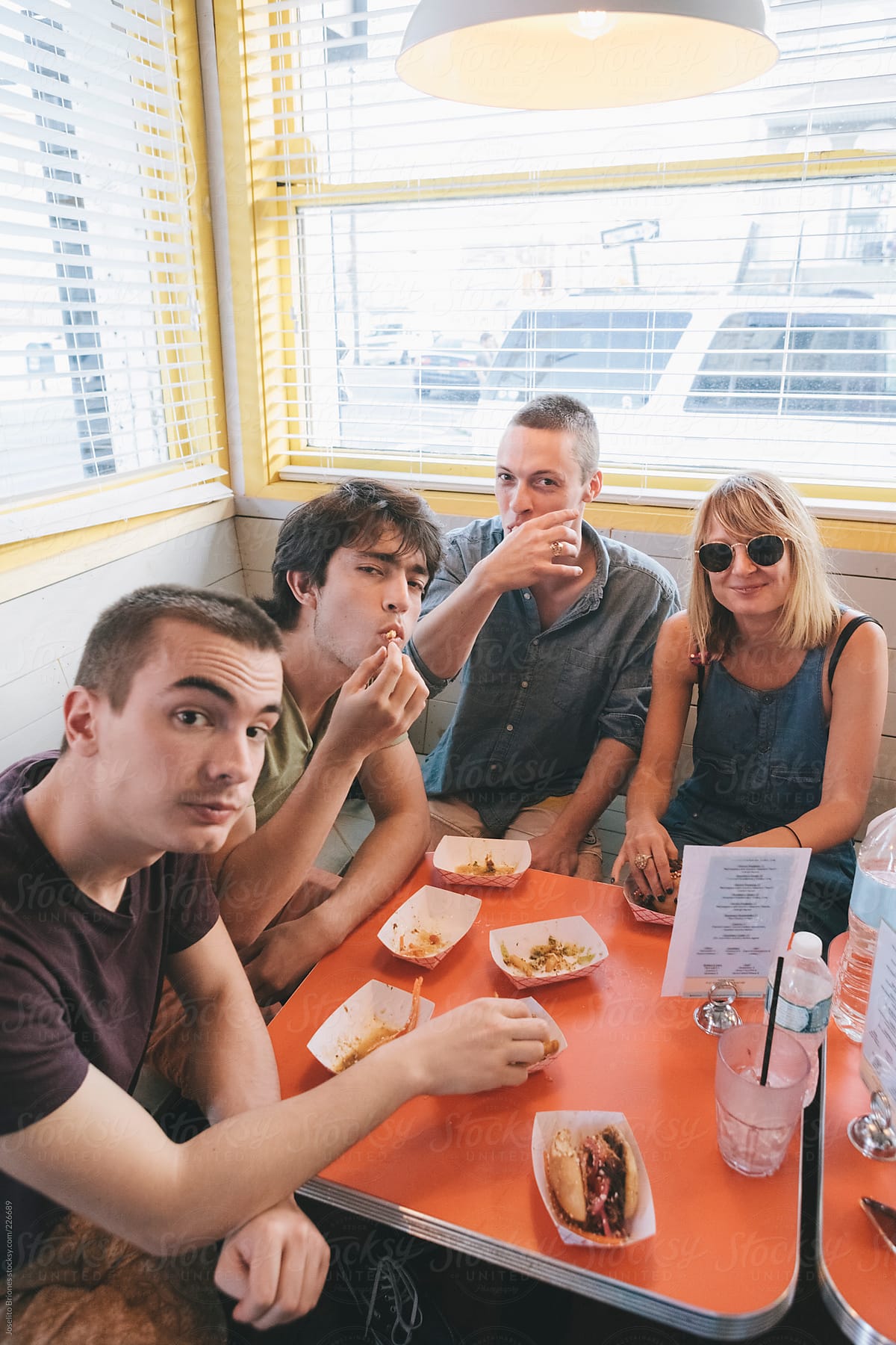 Group of Young Friends Eating Burger Sliders and Fries in a Beach Diner