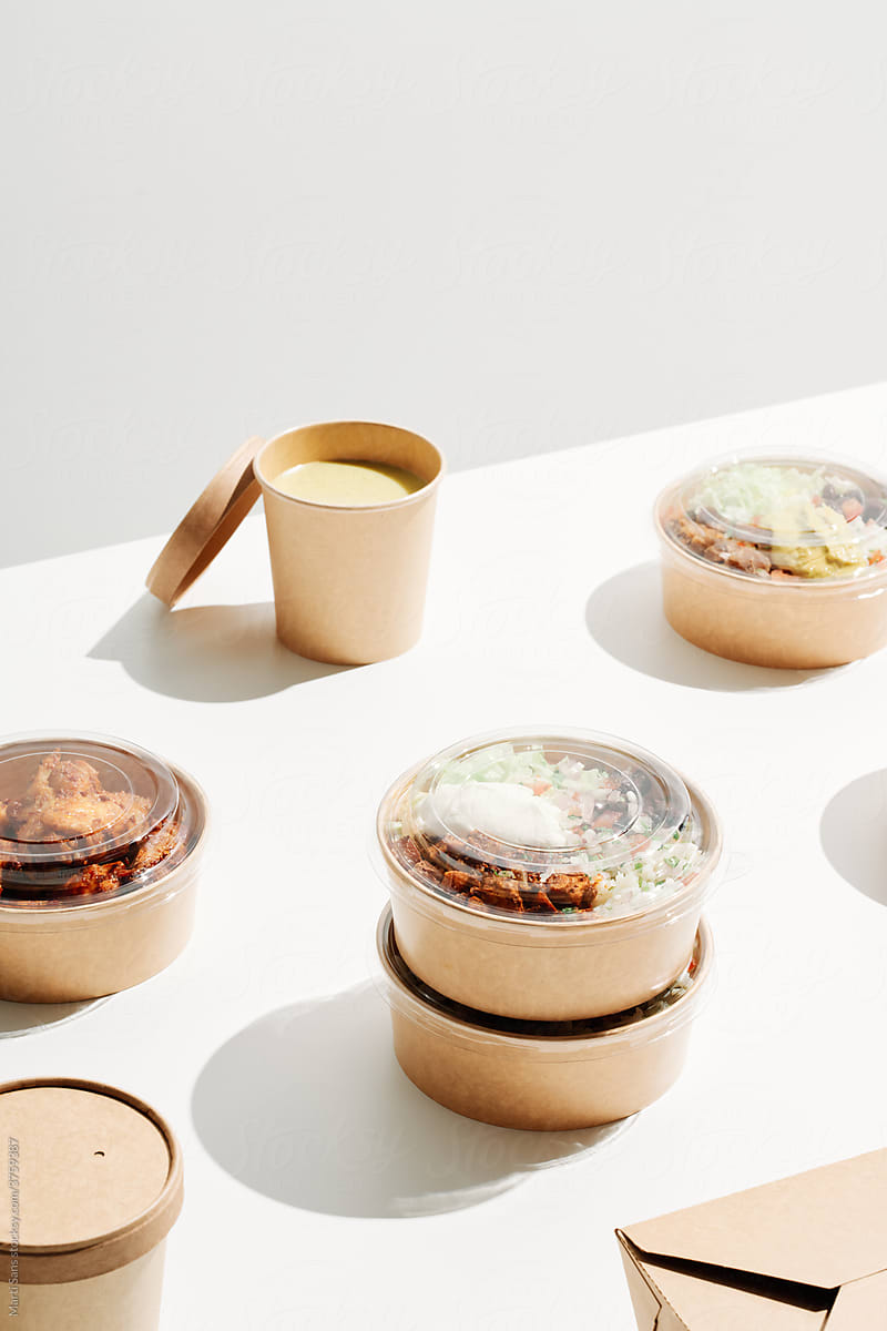 Carton bowls with delivered food on table