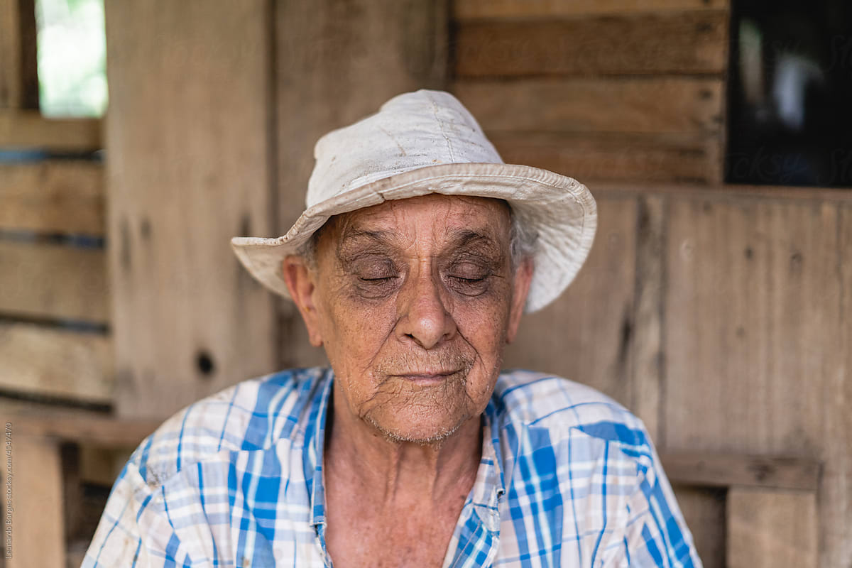 Portrait of an old man with a hat and closed eyes