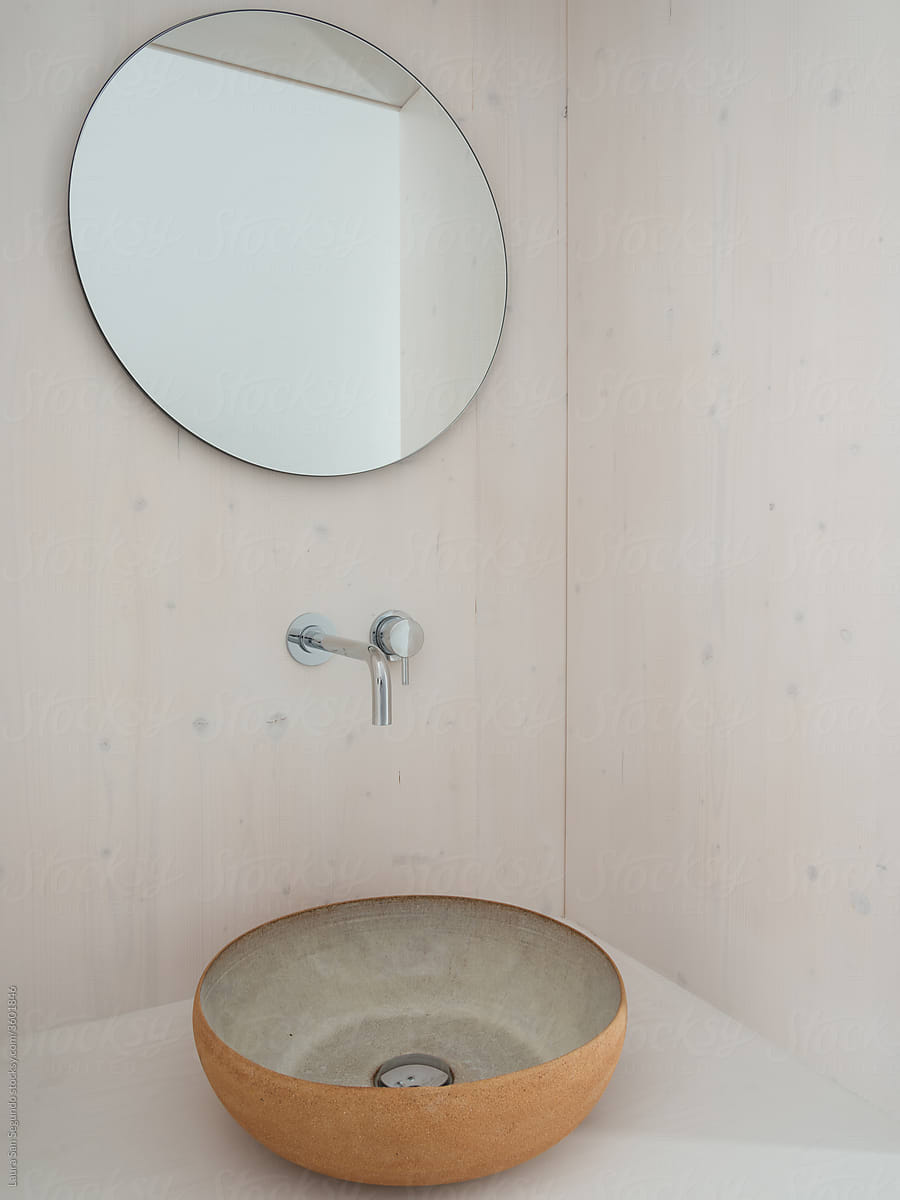 Mirror and ceramic sink in a contemporary minimalist bathroom