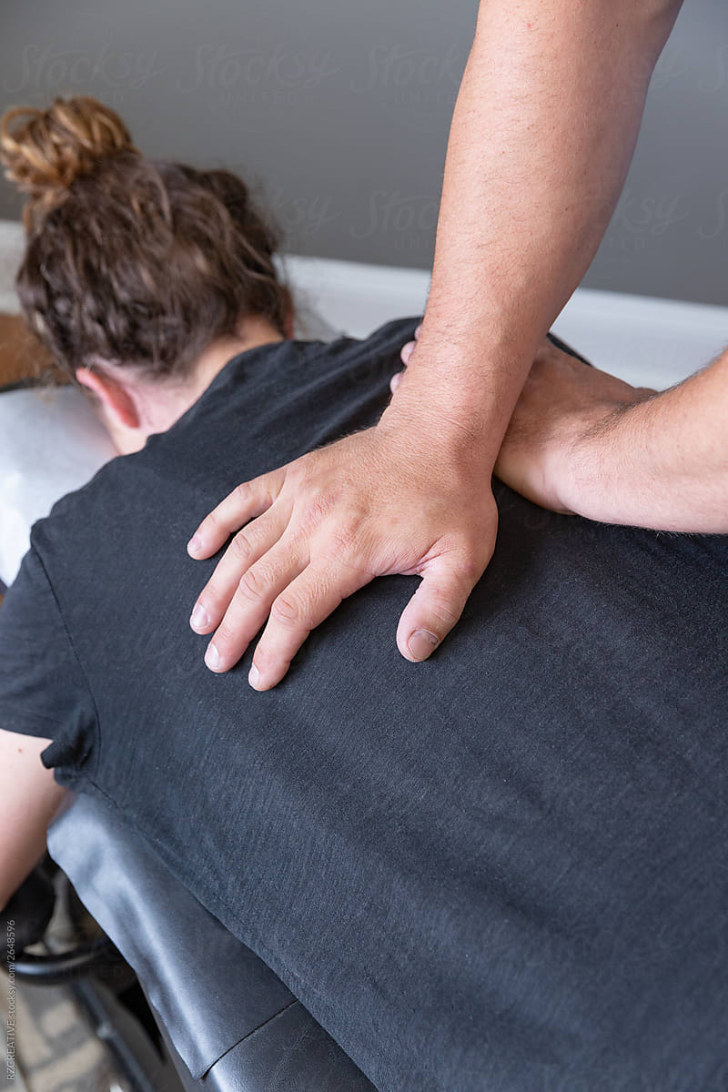 Chiropractor's hands on a woman's back.