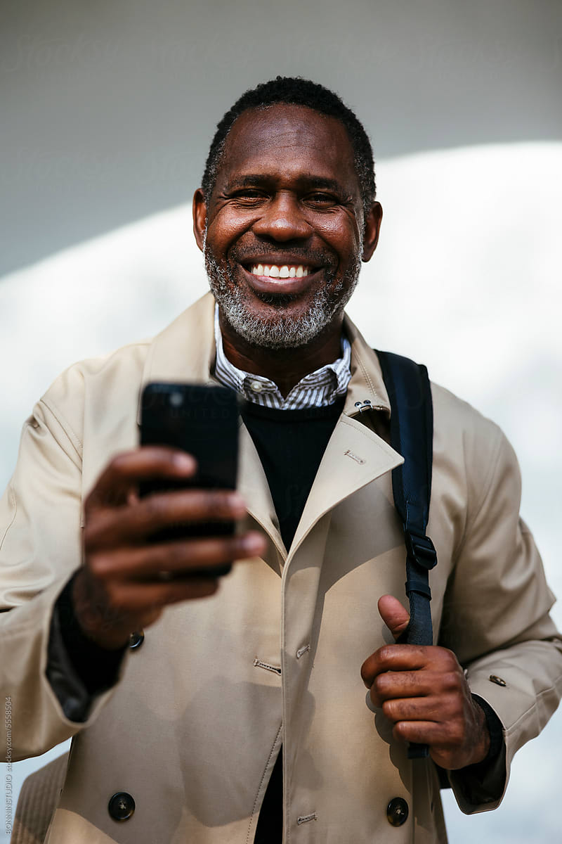 Cheerful mature man with smartphone