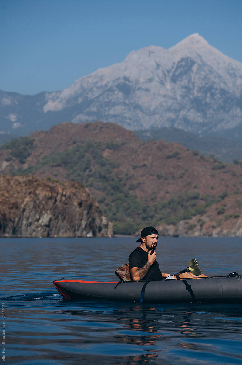 Man floating in kayak in sea