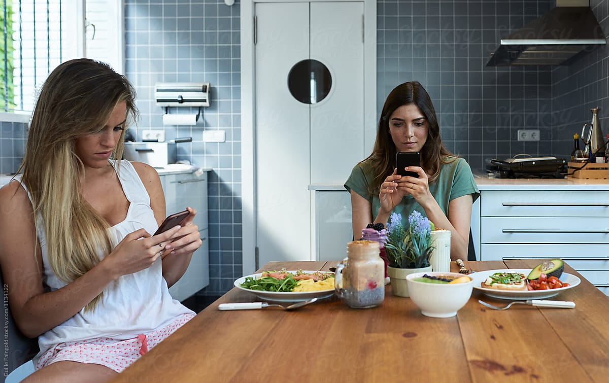 Two Addictive Girlfriends Using Their Phones By Stocksy Contributor