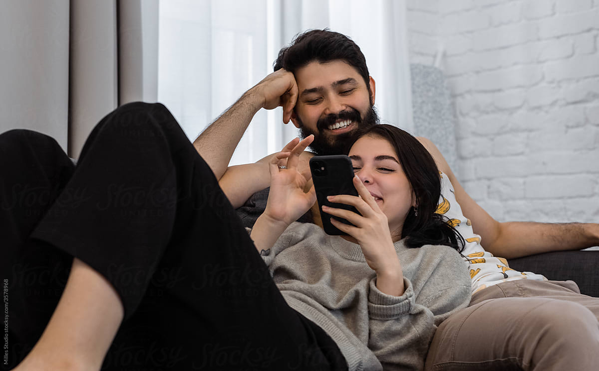 Happy couple using smartphone together