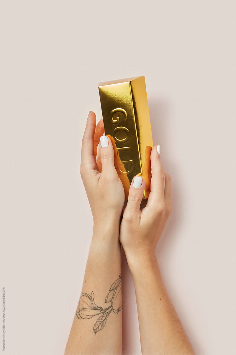 Golden Bar In Woman's Hands On Beige Background. by Stocksy Contributor  Yaroslav Danylchenko - Stocksy