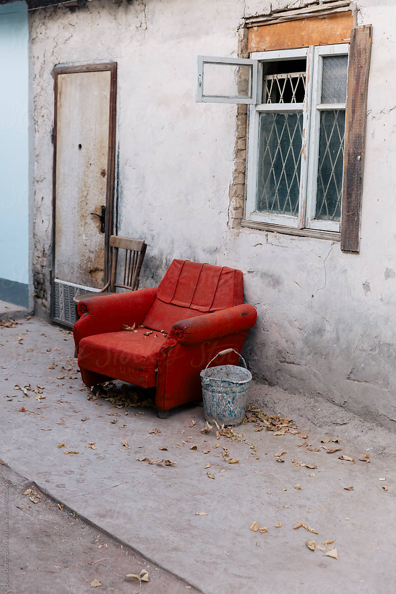 An Old Red Armchair Outside A House