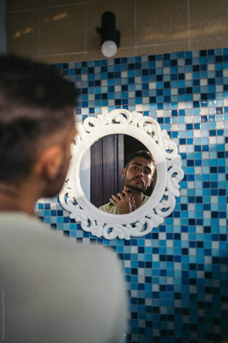 Man trimming his beard in the bathroom