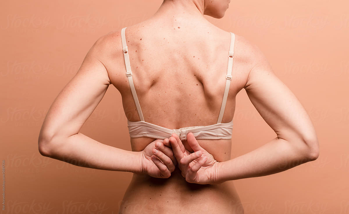 Woman taking off bra studio portrait