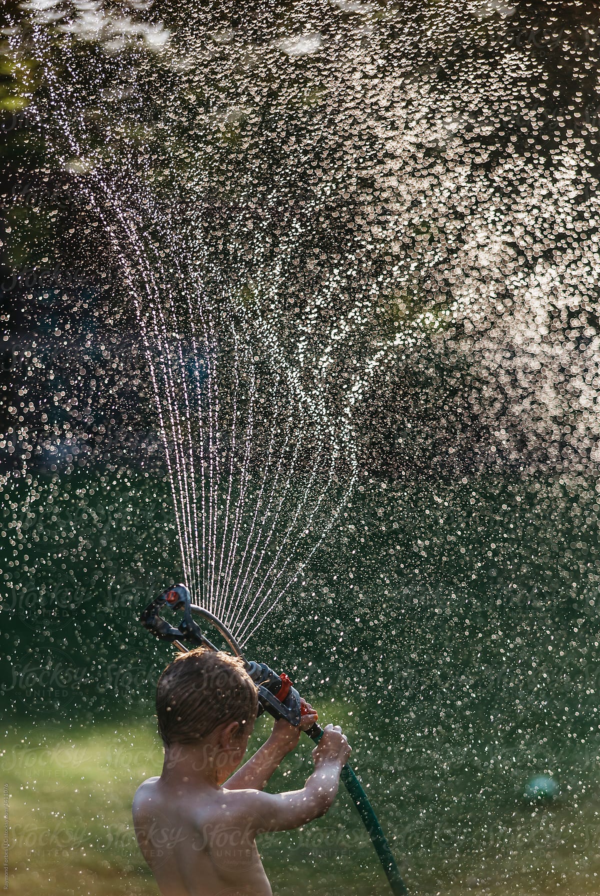 Child Playing with Sprinkler Water