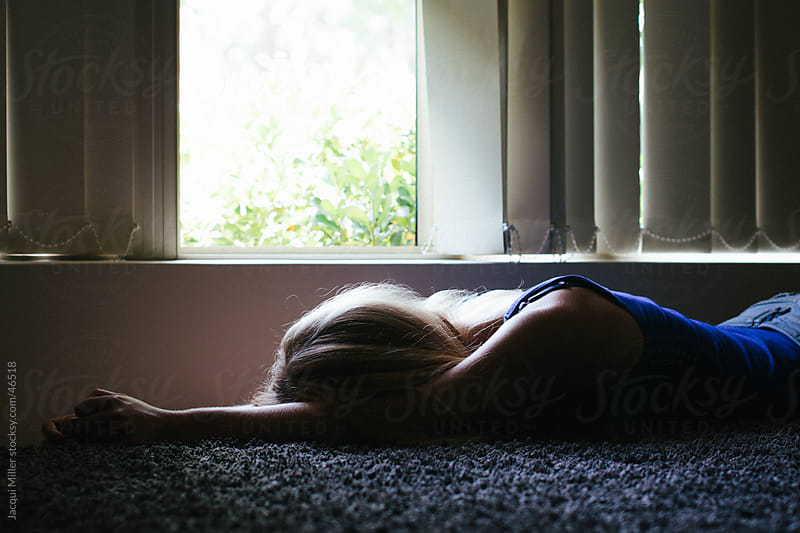 Teenage Girl Lying Face Down On A Rug In Front Of A Window By Jacqui