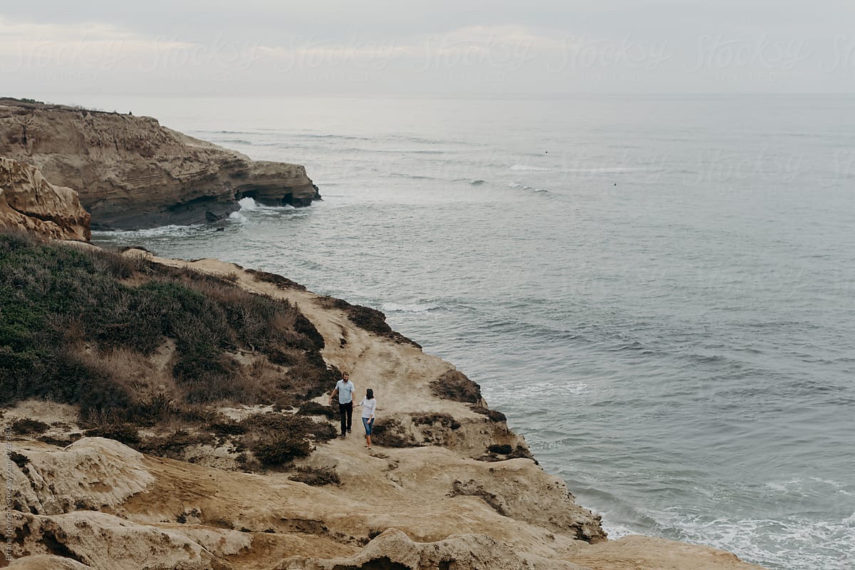 Far off Portrait of a Couple Walking Along Ocean Cliffs