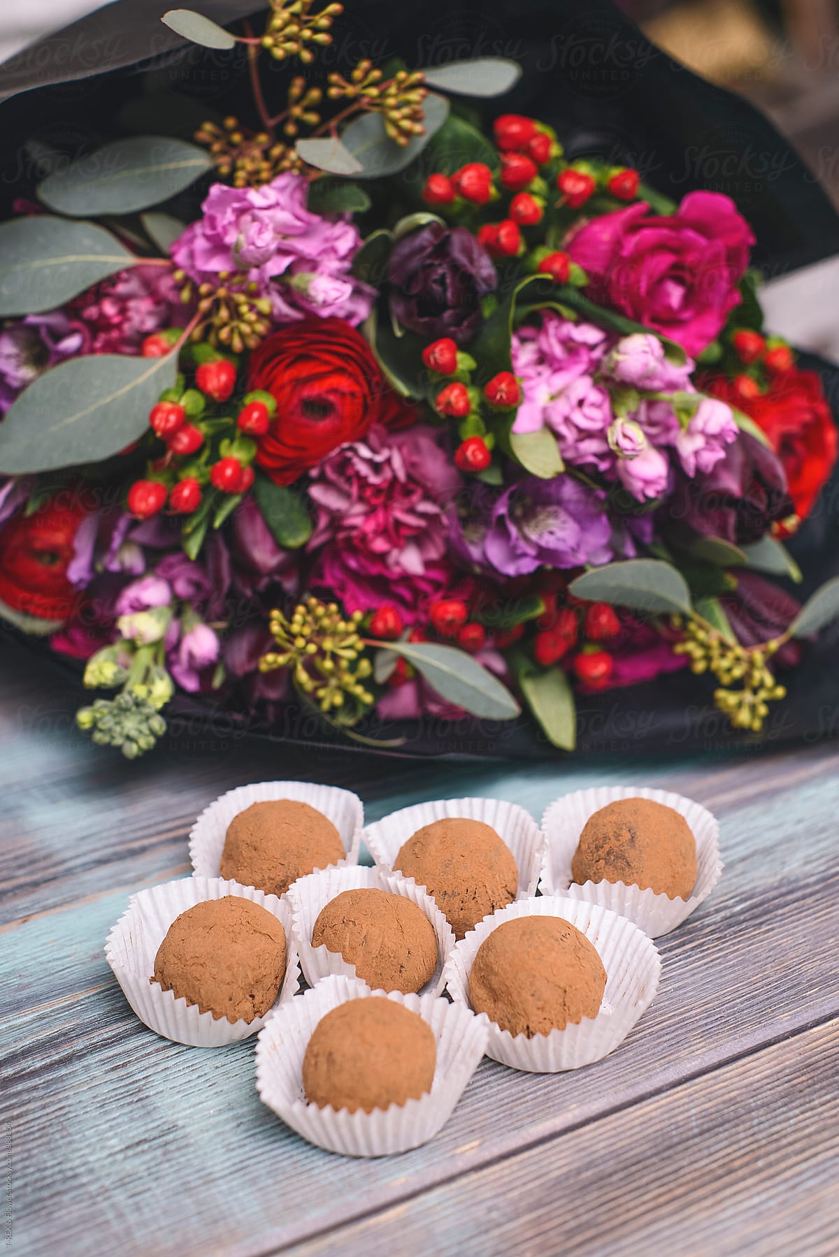 Delicious chocolate truffles against of bright bouquet