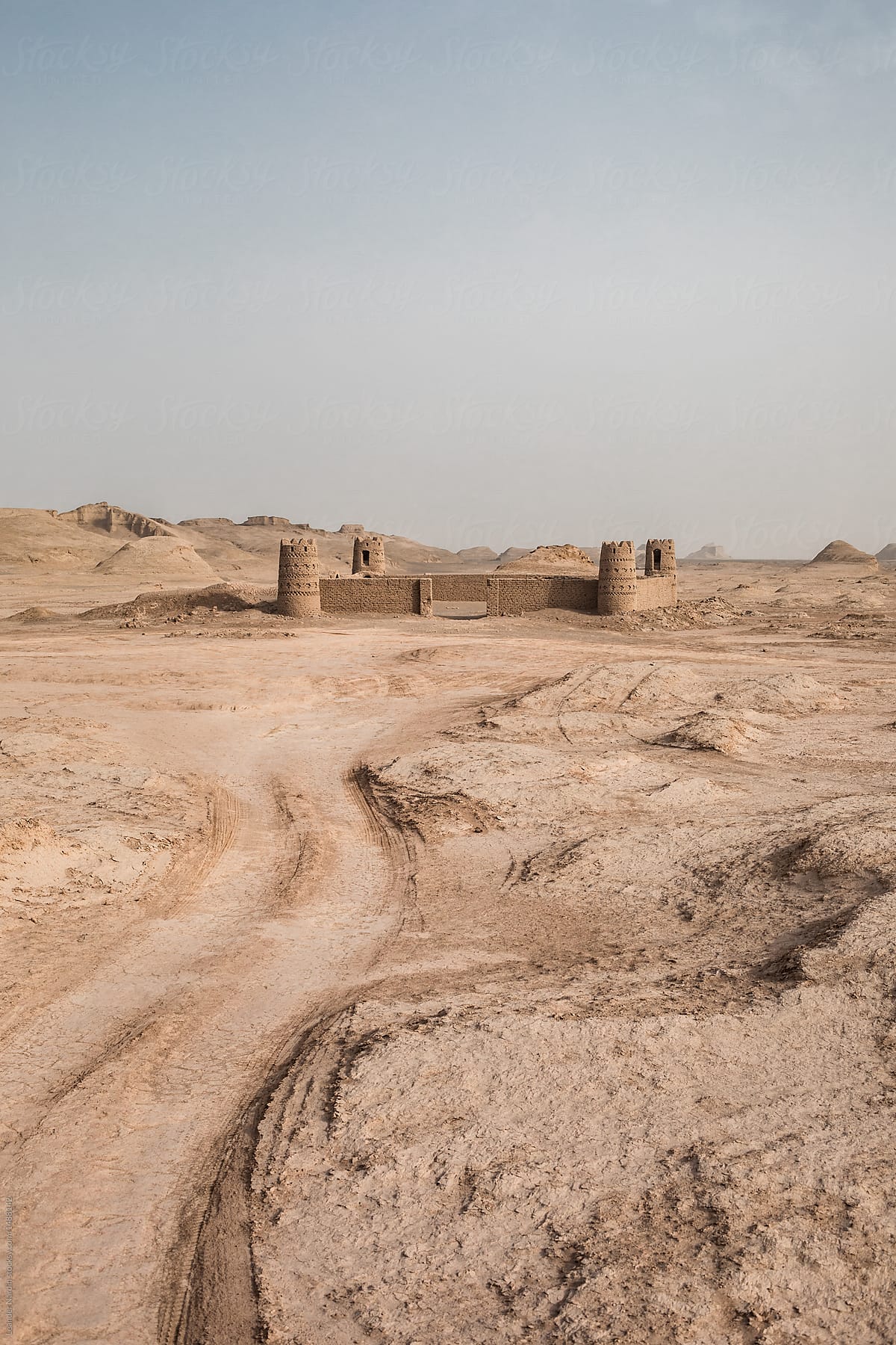 dirt road leading to former fort in persian desert