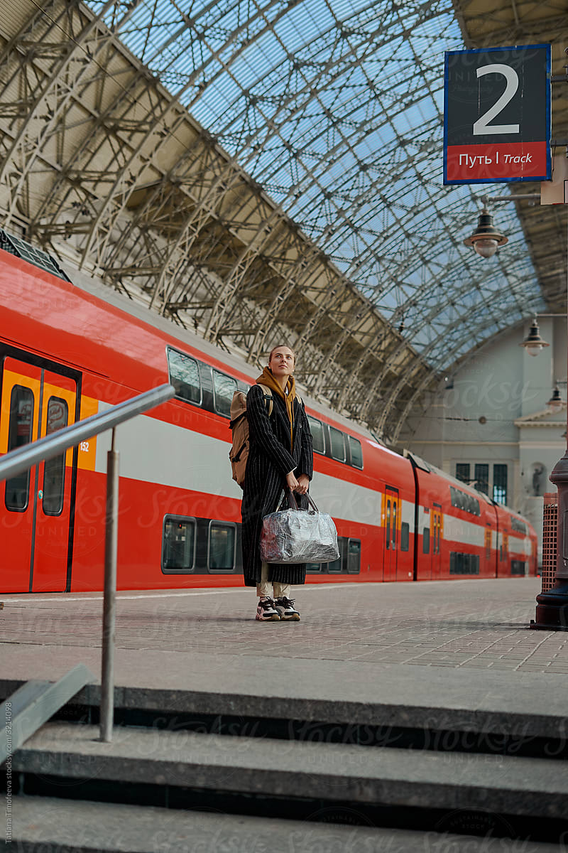 woman stands on train station
