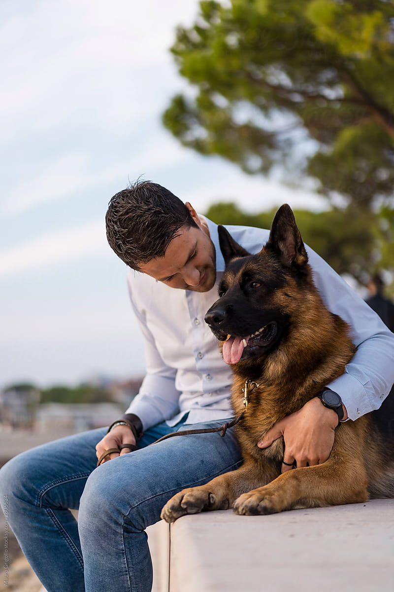 Man outdoor with his german shepherd dog