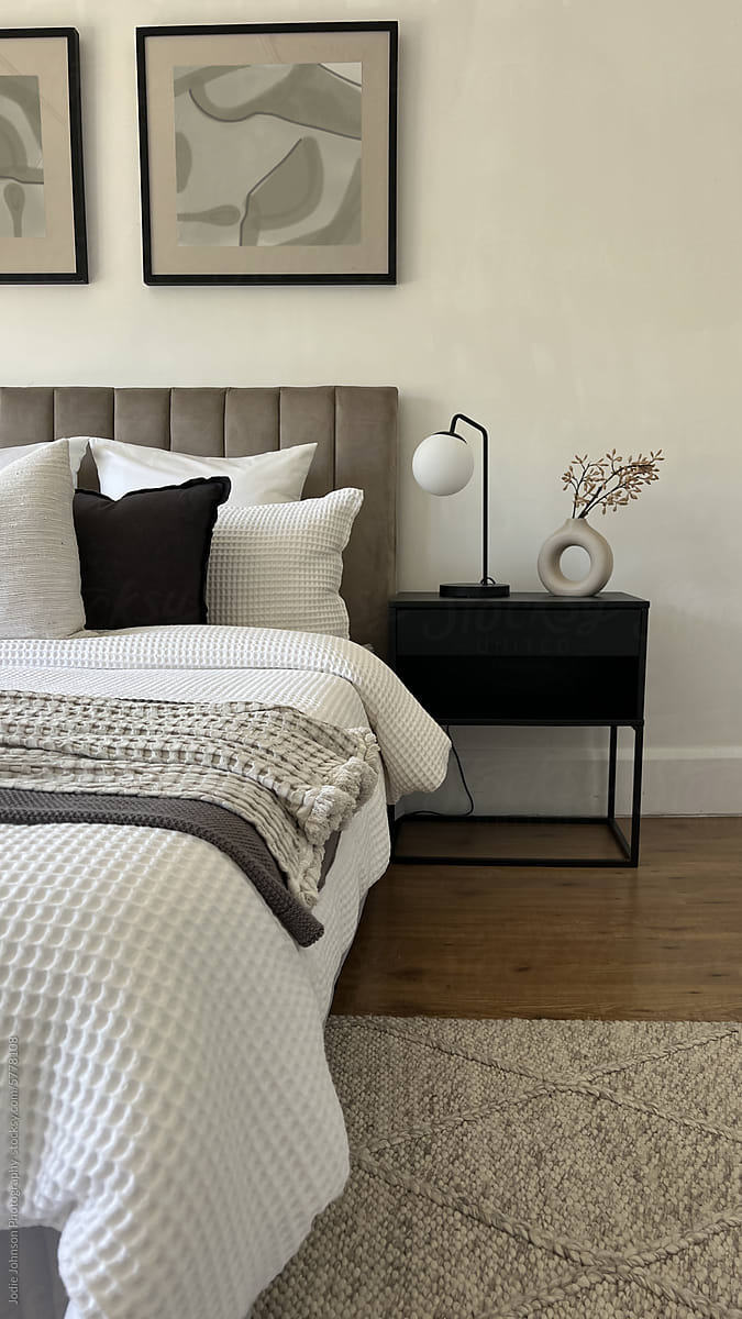 A modern styled bed and bedside table with rug