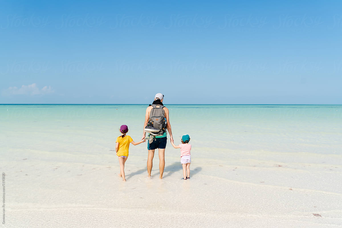 Father traveling with kids on beach