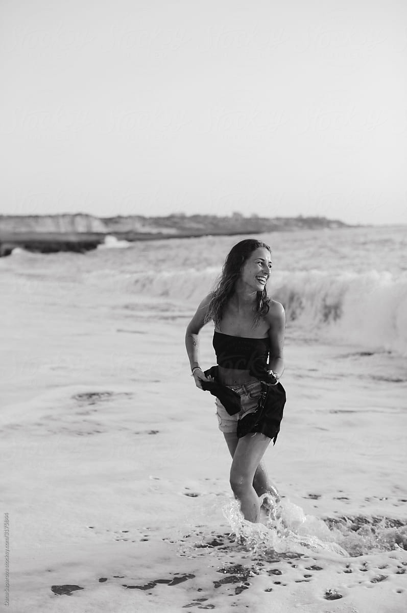 Black and white portrait of woman having fun in the waves