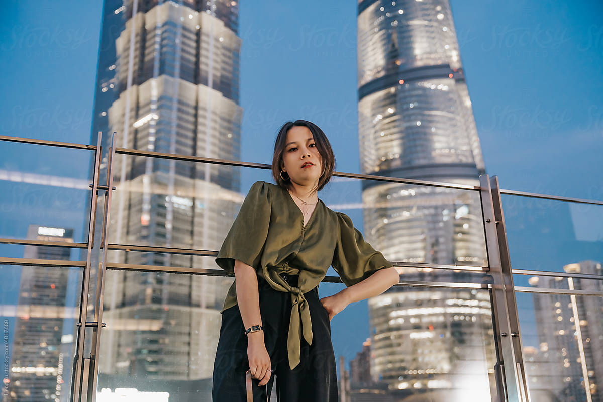 Asian woman standing before night city background