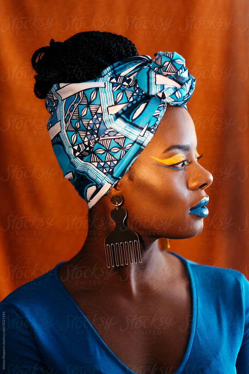 Girl with African print head band and creative makeup in profile