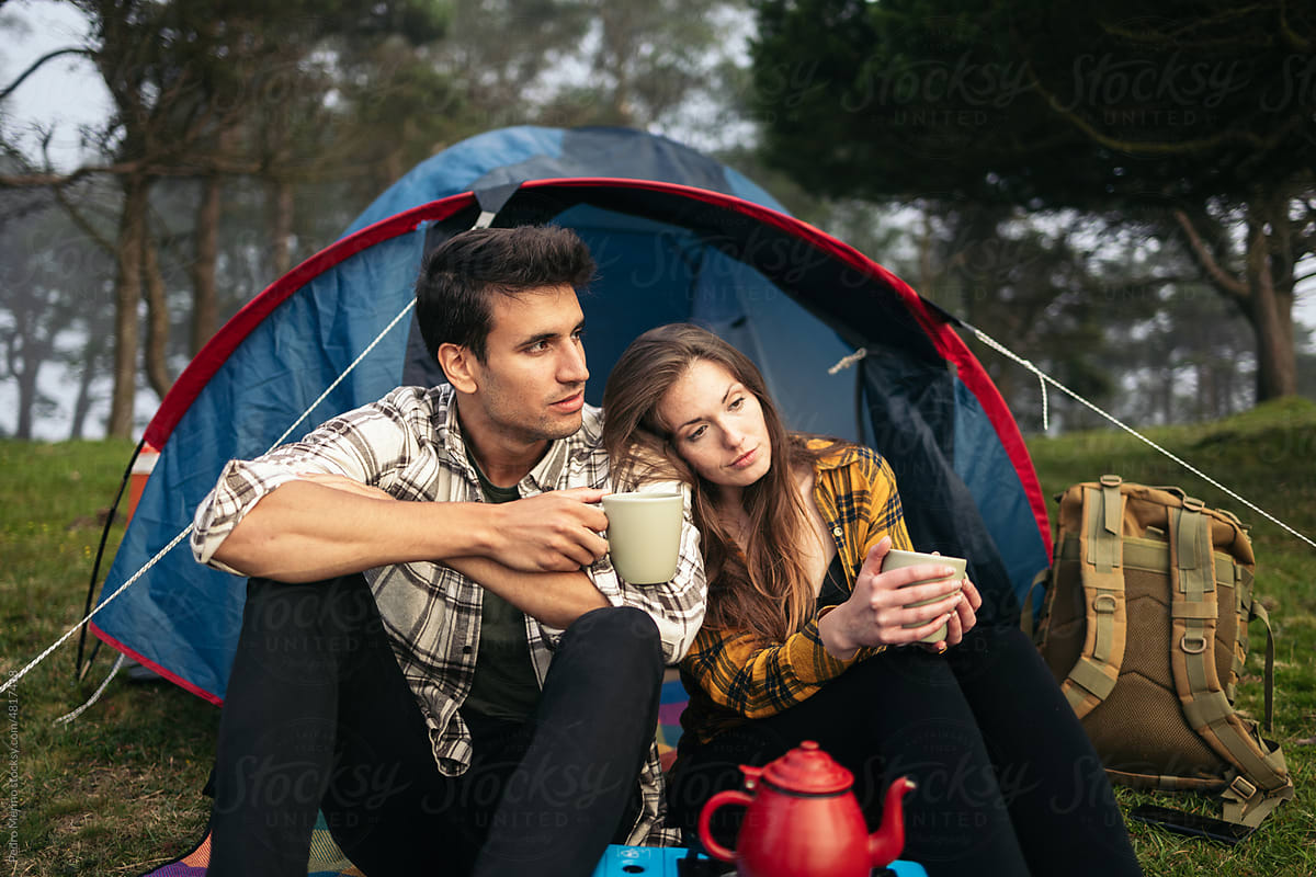 Couple camping in the forest and using camping gas