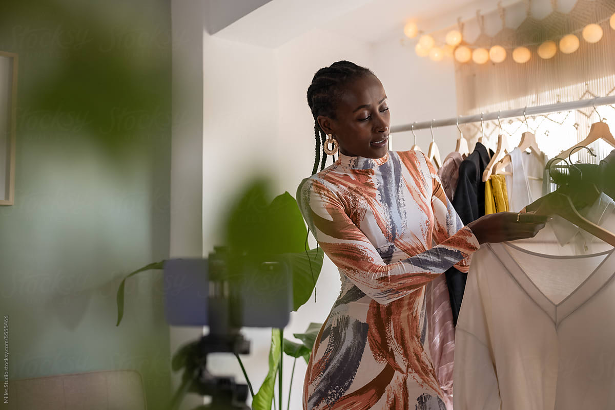 Black female influencer choosing wear from rack