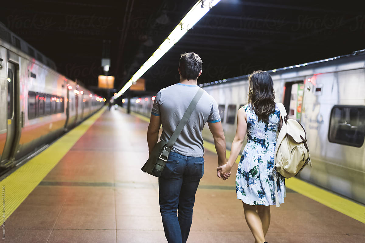 Young couple walking hand in hand in the station