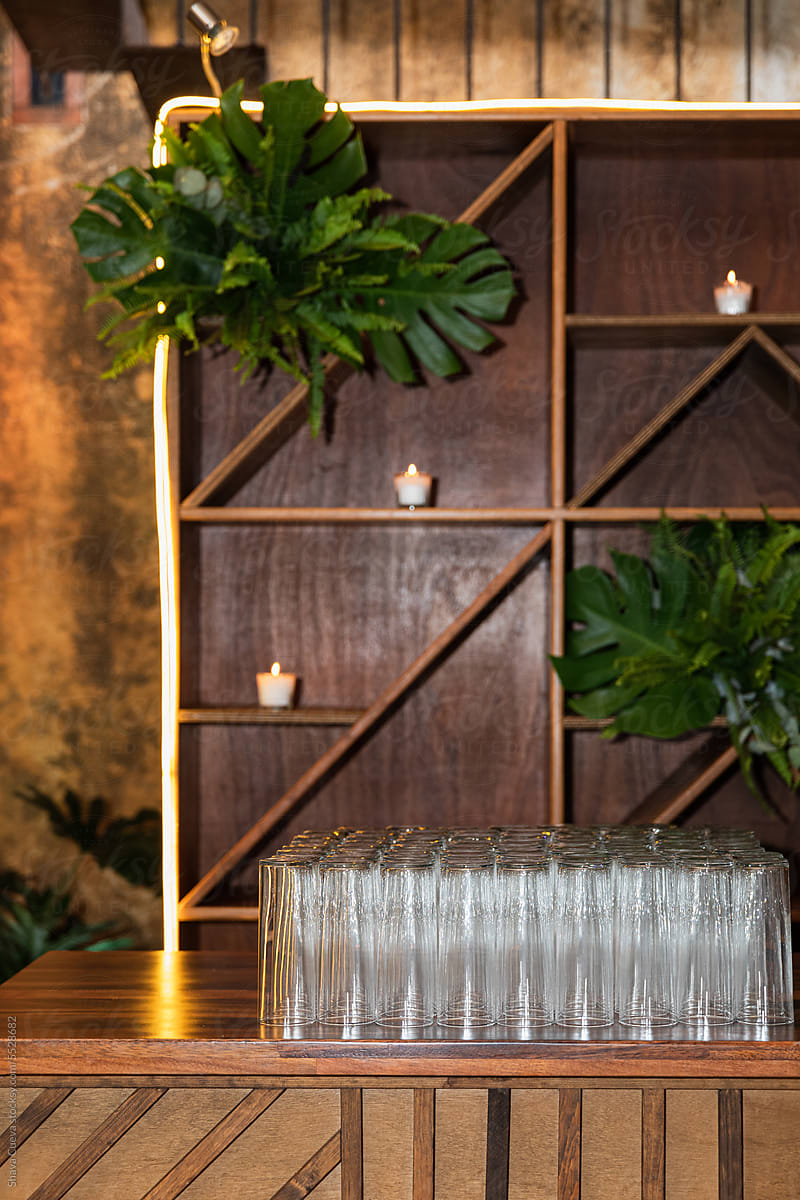 A wooden bar with tall transparent glasses