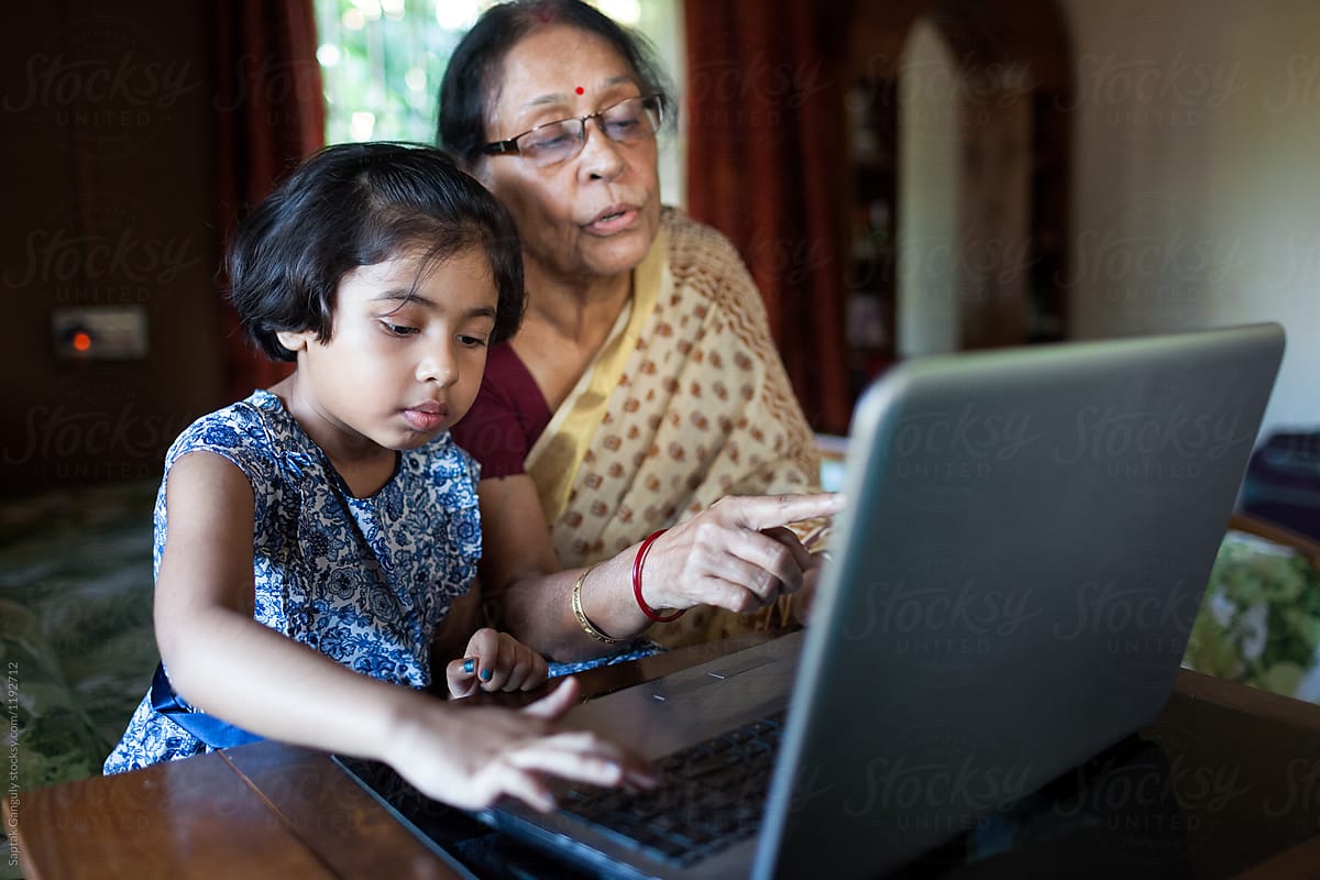 Little girl and her grandmother using laptop